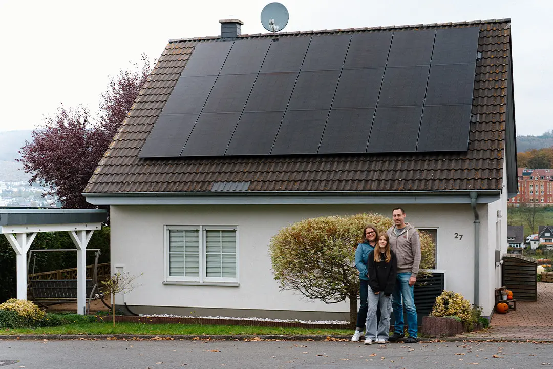 Familie vor Haus mit Photovoltaikanlage